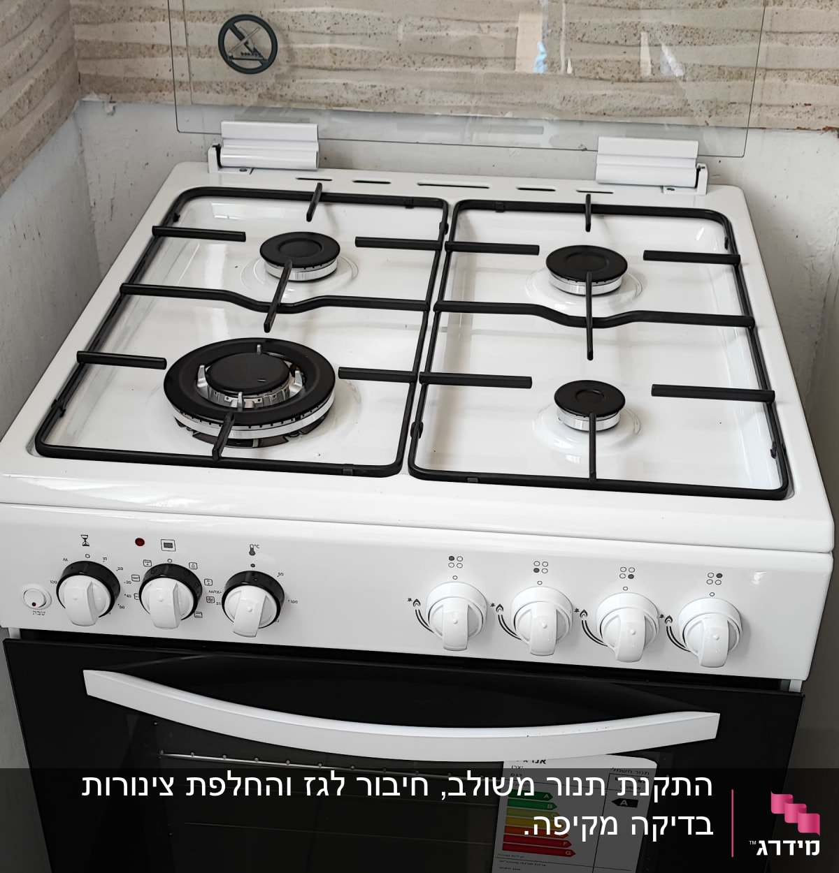 תנור גז לבן עם ארבעה מבערים וכפתורי שליטה